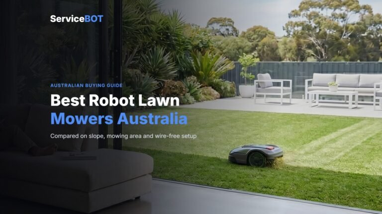 A robot lawn mower cuts stripes into a sunny backyard lawn beside a patio, seen from a lounge room